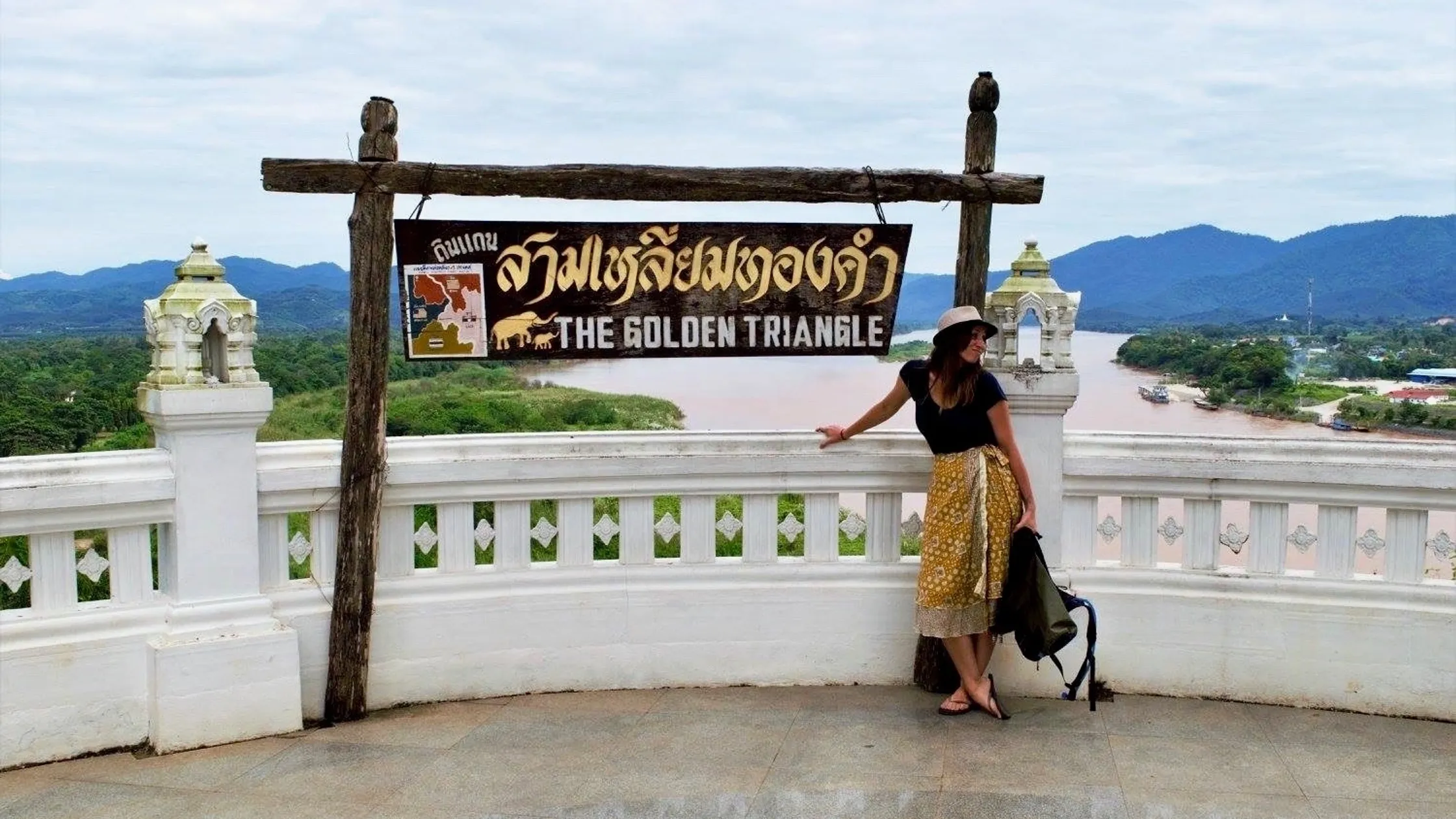 Woman posing at Golden Triangle viewpoint sign.