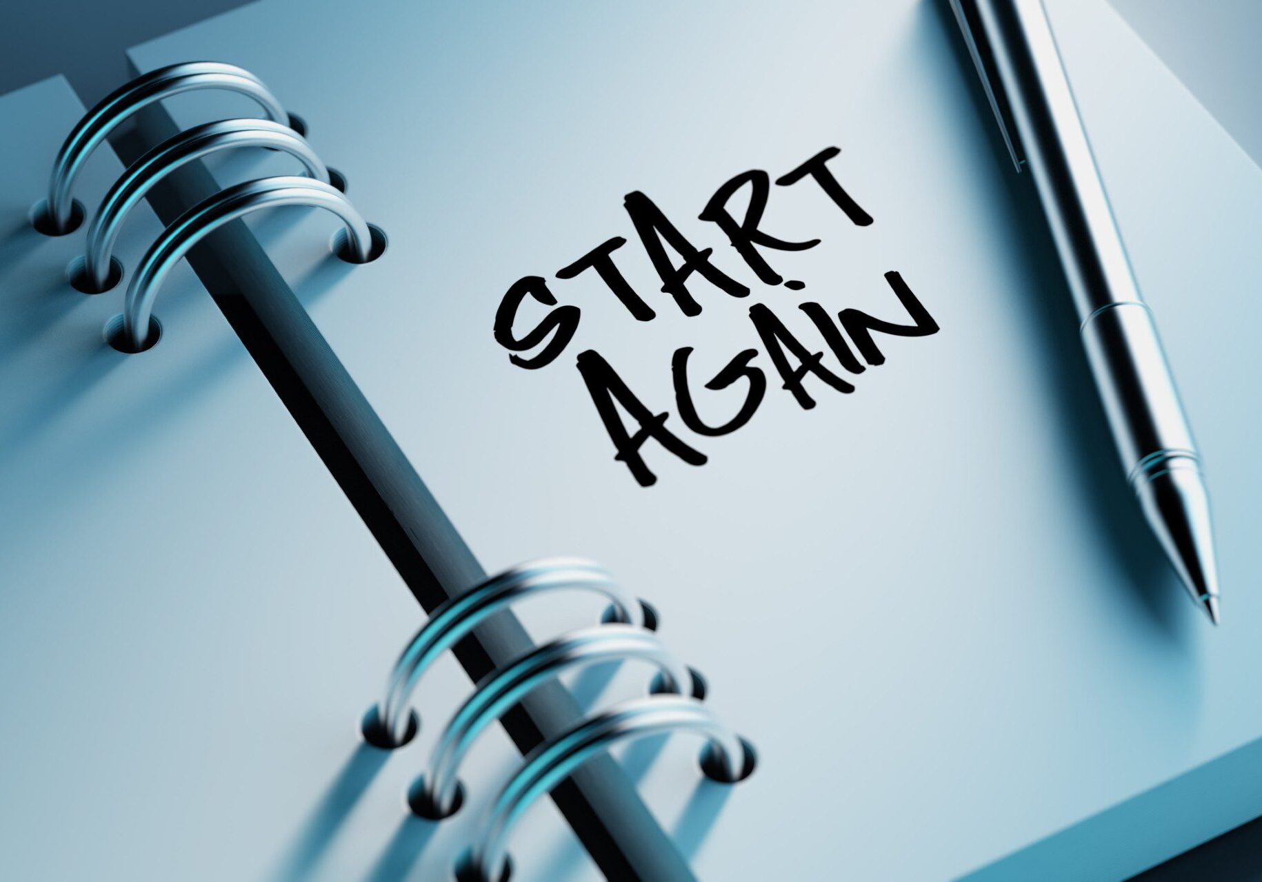 Notebook with "Start Again" and pen.